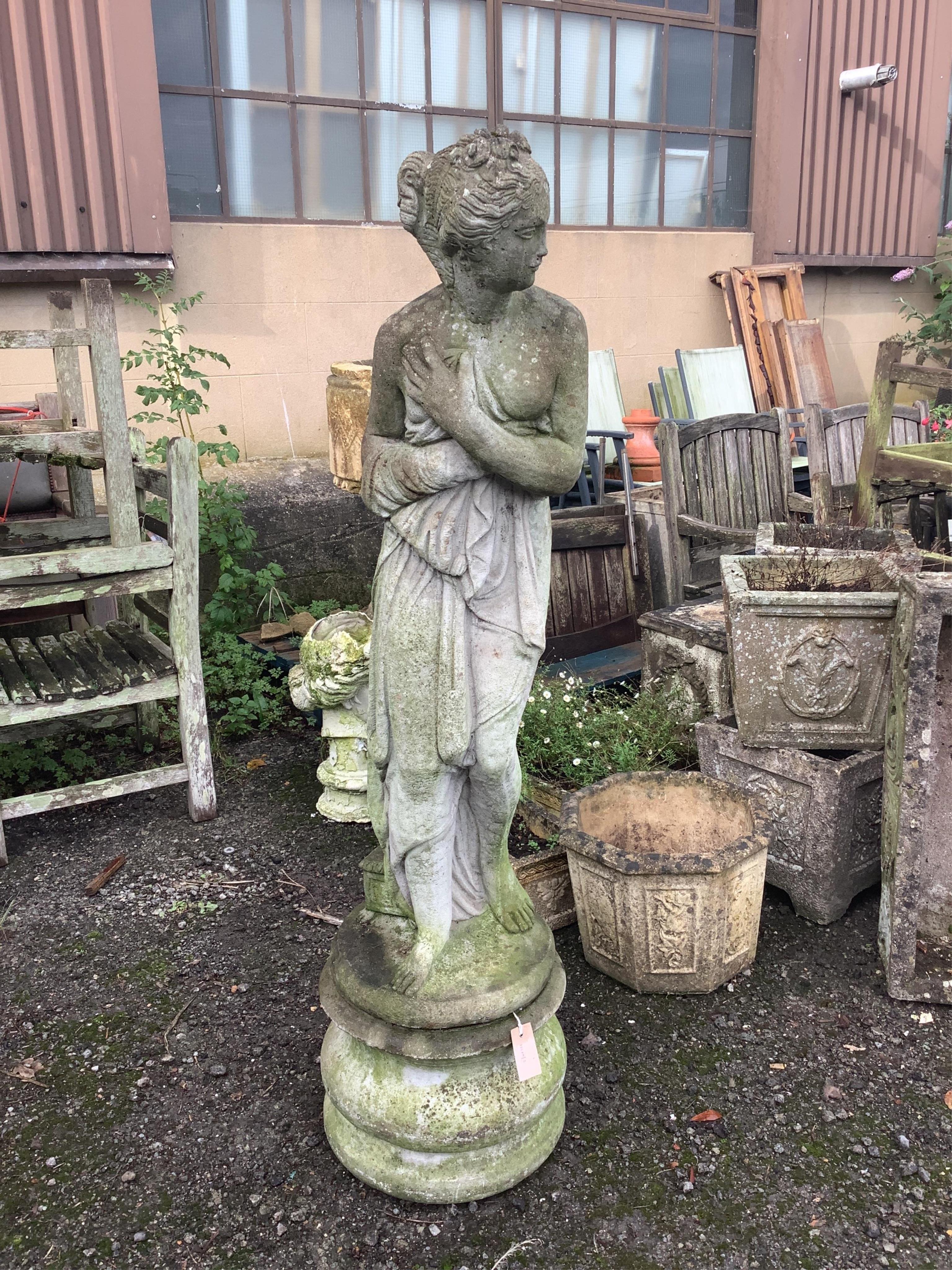 A reconstituted stone female bather garden ornament on a circular pedestal, height 144cm. Condition - fair